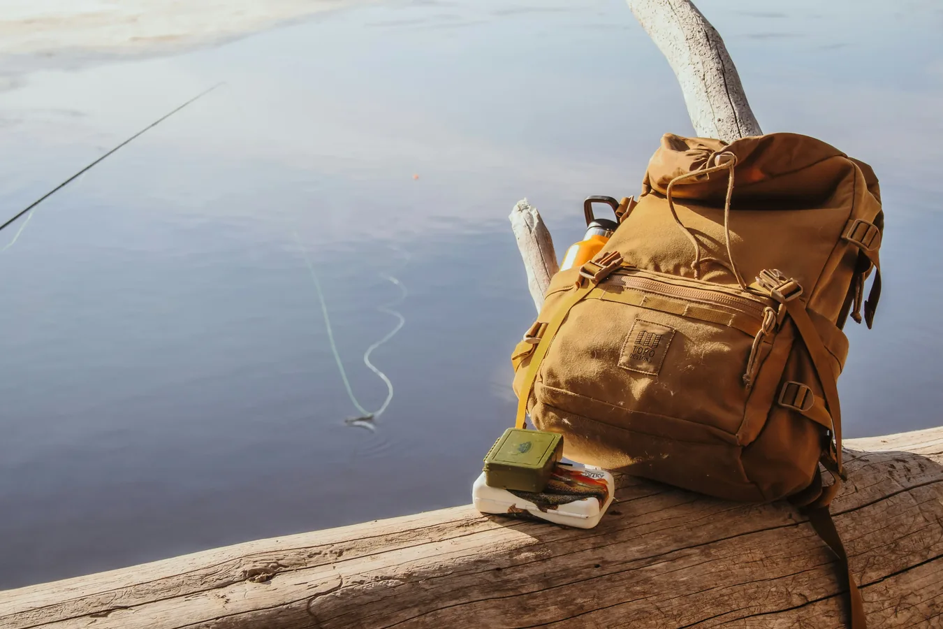 Mochila técnica de pesca con cajas organizadoras junto a cañas y equipo
