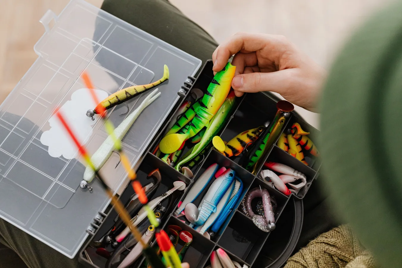 Caja organizadora de pesca abierta mostrando señuelos y accesorios ordenados