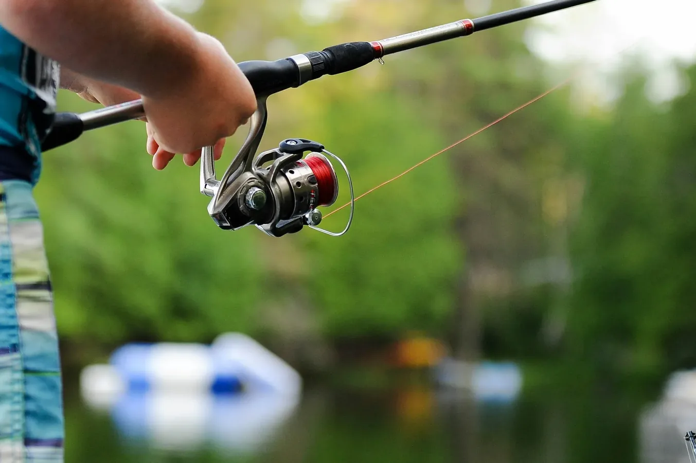 Primer plano de un carrete de pesca de spinning montado en una caña