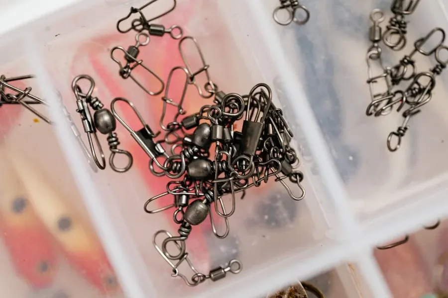 Primer plano de emerillones giratorios y clips rapidos atados a la linea de pesca