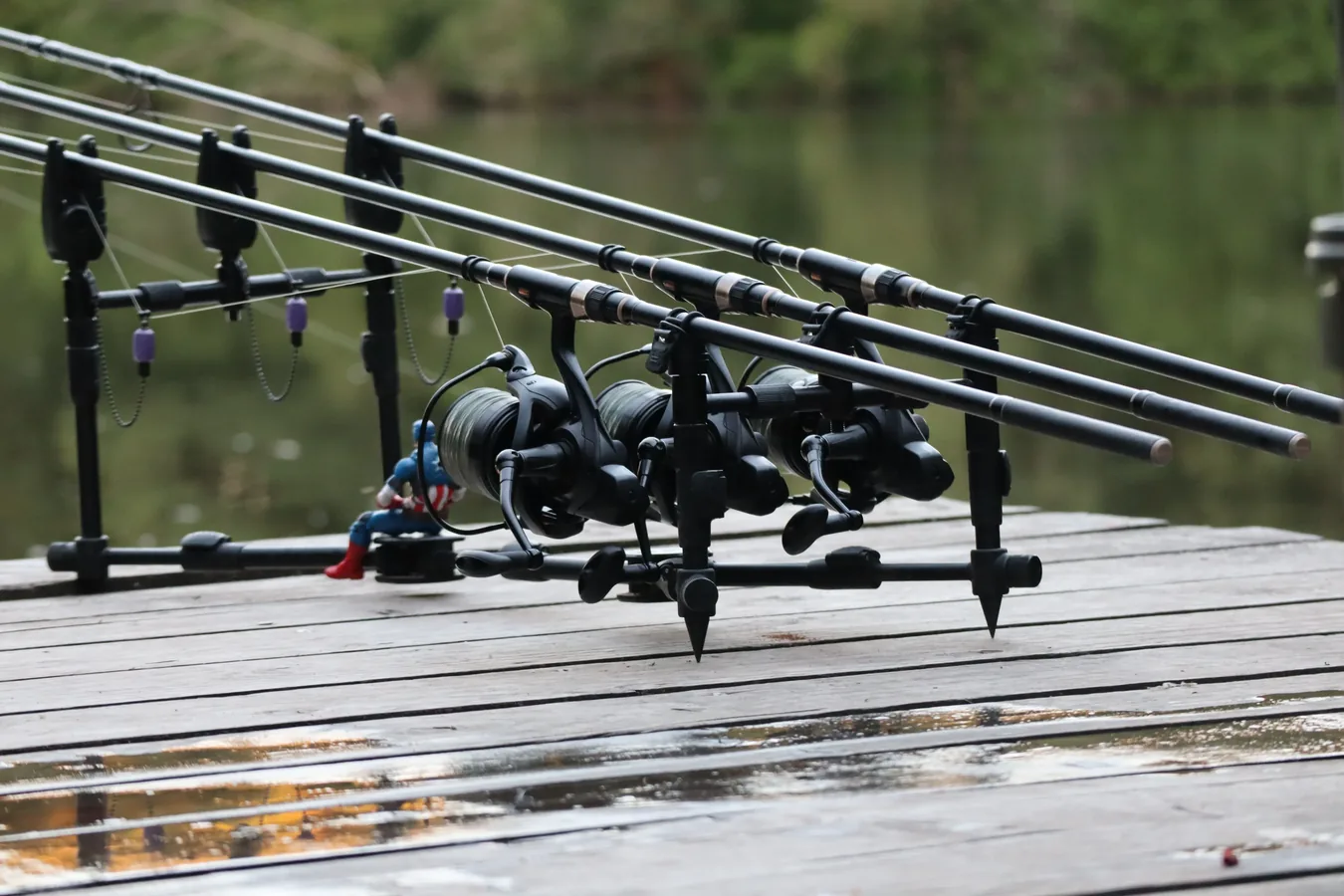 Pequeño material de carpfishing con swingers, bolsas de PVA y giratorios organizados sobre una mesa