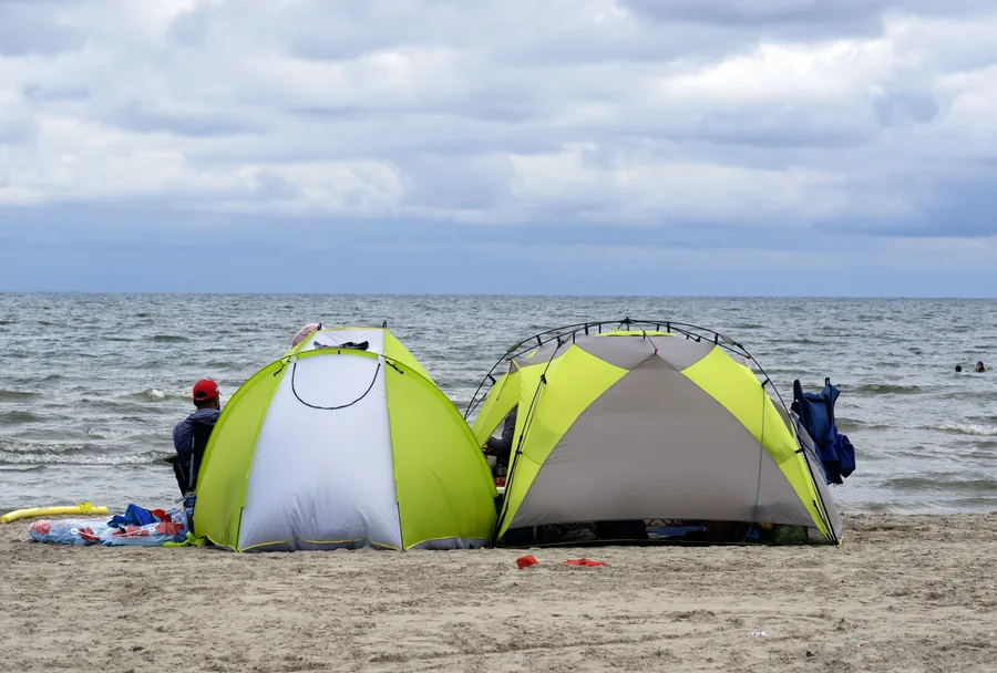 Carpas/refugios de camping junto al agua, similares al bivvy usado para proteger el puesto de pesca