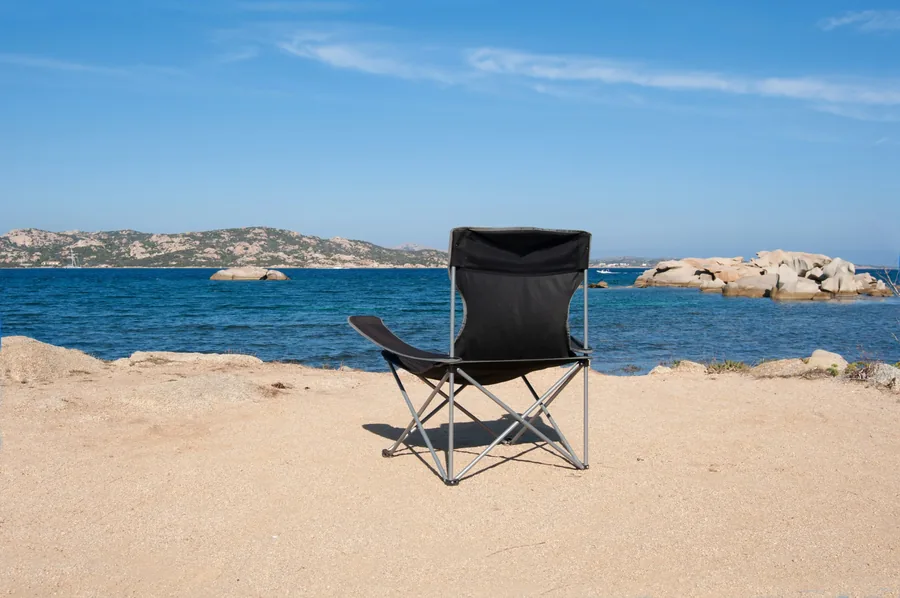 Silla plegable de camping junto al agua, equipo de descanso para sesiones largas de pesca